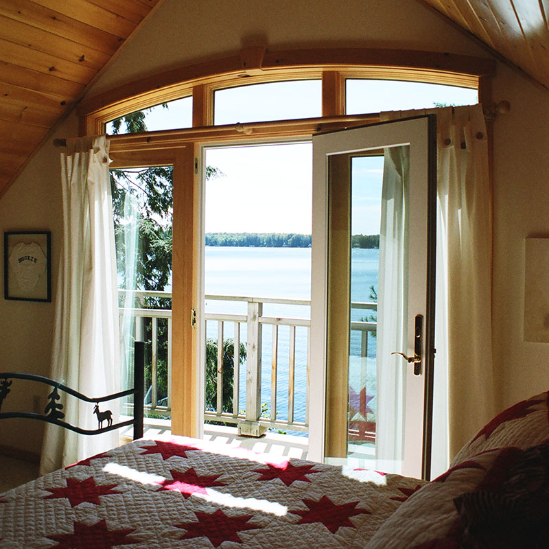 architect designed cottage addition - lake muskoka - bedroom doors overlooking lake S